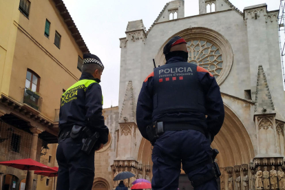 Dos agentes, uno de Mossos y uno de Guardia Urbana, delante de la Catedral.
