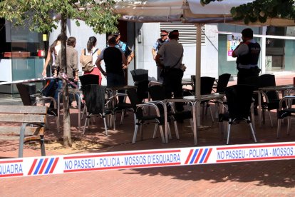 Imagen del precinto y agentes de las fuerzas policiales en la puerta del edificio de Terrassa donde se produjeron los hechos.