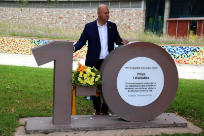 Pla conjunt de l'alcalde de la Ràpita, Josep Caparrós, darrere del monument que recorda els fets de 1-O al municipi. Imatge de l'1 d'octubre de 2019