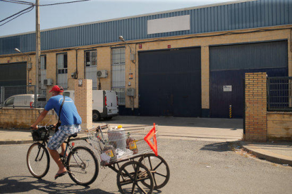 Un home passa amb una bicicleta a prop de la fàbrica Magrudis a Sevilla, focus del brot de listeriosi.