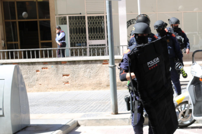 Agentes ARRO de los Mossos d'Esquadra saliendo del portal de un bloque de pisos de Valls.
