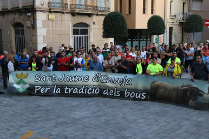 Un grup d'aficionats amb pancartes davant l'Ajuntament d'Amposta durant la reunió dels alcaldes.