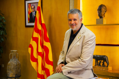 Pau Ricomà al seu despatx a l'Ajuntament, amb les imatges dels presidents de la Generalitat Quim Torra i Lluís Companys al darrere.