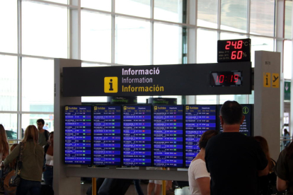 Plano medio de un panel informativo de vuelos de salida al aeropuerto del Prat, con ningún vuelo cancelado.