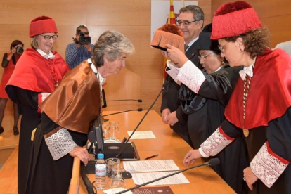 Bettina Kadner rep el birret de mans de la rectora María José Figueras.