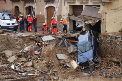 Imatge d'efectius treballant per retirar un cotxe arrossegat per la riuada durant el temporal a Montblanc