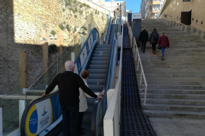 Dues persones dubten a pujar per les escales espatllades i altres tres fan el tram afectat a peu.