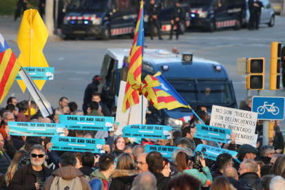 Un grup de manifestants amb banderoles amb el lema 'Spain, sit and talk' davant de dispositius dels Mossos d'Esquadra a l'entorn del Camp Nou