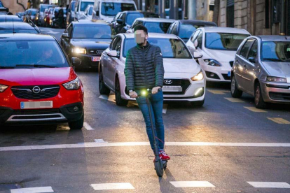 Un usuari d'un patinet elèctric per un carrer de Tarragona.