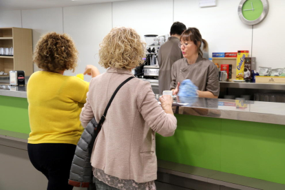 Dos usuarias siendo atendidas en la barra del nuevo servicio de cafetería del Hospital Comarcal de Mora.