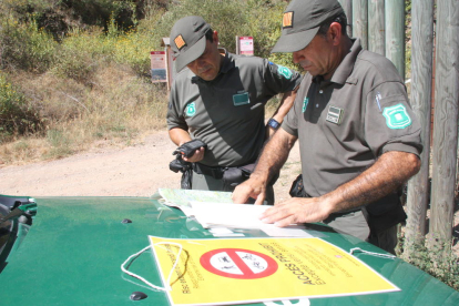 Els Agents Rurals, repassant la cartografia del Parc Natural del Montsant, durant el tancament d'un dels punts d'accés, a Escala Dei.