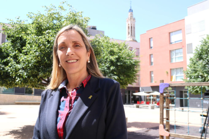 Dolors Farré, candidata de Junts per Valls i futura alcaldessa de la ciutat, en una plaça amb el campanar de Sant Joan al fons.