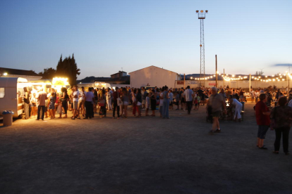 Plano general de multitud de personas en el Festival de Cinema de la Terra Alta, con 'foodtrucks', barra de bar y música en directo en la zona deportiva de Bot.