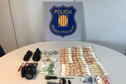 Imagen de los objetos y el dinero intervenido a los autores del robo en el interior de un vehículo.