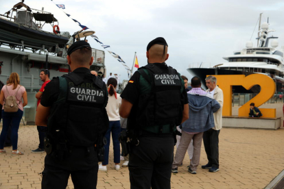 Pla obert de dos agents de la Guàrdia Civil d'esquenes fent tasques de vigilància del patruller Infanta Cristina ubicat al Moll de la Costa del Port de Tarragona. Imatge del 12 d'octubre del 2019 (Horitzontal).
