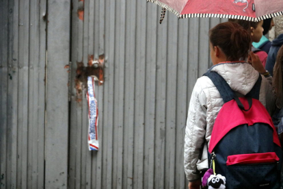 Una alumna se mira los desperfectos de la puerta del colegio Verd de Gerona, el 2 de octubre del 2017.
