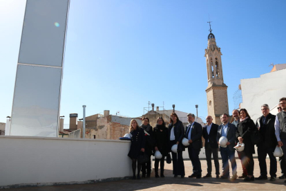 Foto de familia en la terraza del Museu Casteller de Catalunya en Valls, en una visita de obras con la consellera de Cultura, Laura Borràs, con el campanario de la ciudad en el fondo.
