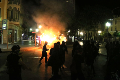 Pla genera de manifestants i contenidors cremant al fons de la Rambla Nova de Tarragona. Imatge del 16 d'octubre de 2019