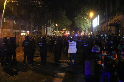 Cordó dels Mossos, en primer terme davant de la línia de manifestants, al voltant de la delegació del govern espanyol a Barcelona el 15 d'octubre.