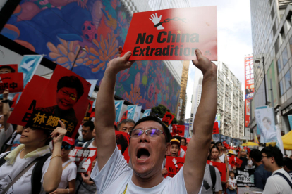Un hombre sosteniendo un cartel donde se puede leer en inglés «No China Extradition», en la manifestación en Hong Kong en contra de la ley de extradición.