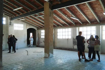 Personas recorriendo el interior de un antiguo inmueble del centro histórico de Valls que se integrará en una promocíó de viviendas sociales gestionadas por la cooperativa La Titaranya.