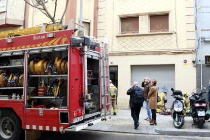Un vehicle dels Bombers davant l'edifici on tres persones han perdut la vida en l'incendi d'un pis, a l'Hospitalet de Llobregat.