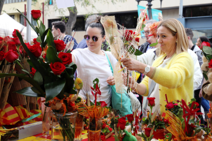 Image de dues dones comprant roses Durant la Diada de Sant Jordi a la Rambla Nova de Tarragona.