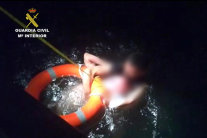 Agentes de la Guardia Civil tirando un salvavidas al hombre que estaba en el agua.