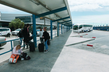 Pasajeros esperan la llegada de autobuses interurbanos a los andenes del aeródromo.