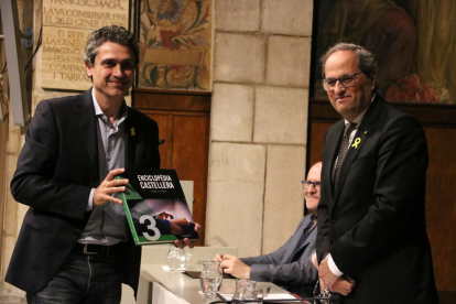 El presidente Quim Torra entrega al representante de una colla castellera un ejemplar del tercer volumen de la Enciclopèdia castellera.