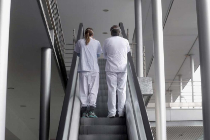 Imagen de archivo de dos enfermeras subiendo unas escaleras mecánicas.