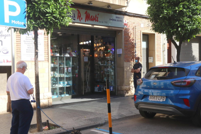 L'exterior de la botiga Elèctrica Ramon Martí de Reus, amb clients fent cua per entrar d'un en un.