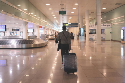 Un viajero caminando con maletas en la zona de llegadas de la T1 en el aeropuerto del Prat el 19 de junio del 2020.