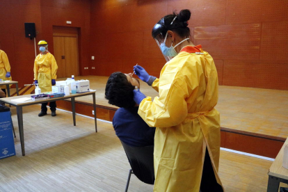 Un sanitario haciendo una prueba PCR a un vecino del barrio de Balàfia de Lleida.