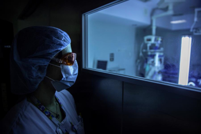 Una sanitària observa el funcionament d'un dispositiu de llum ultraviolada continua (UV-C) mòbil que serveix per desinfectar les estances hospitalàries i eliminar el coronavirus.