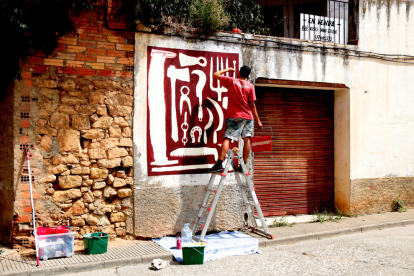 Un artista trabajando en una de las creaciones del festival 'Riu d'Art' de Riba-roja d'Ebre.