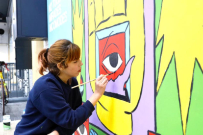 La il·lustradora Cristina Daura mentre pinta un mural en el marc de la campanya 'Tolerància Zero' d'FGC