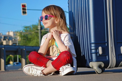 Imagen de una niña con gafas de sol en la calle.