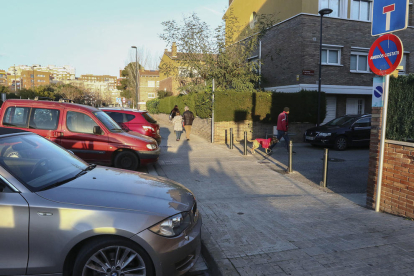 Vehículos de padres estacionados impidiendo el paso de los coches de los vecinos.