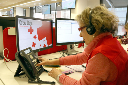 Una voluntaria de Cruz Roja llamando a un usuario para informarlo sobre el coronavirus.
