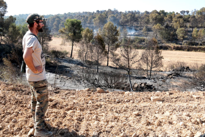 Un vecino de Maials observa la zona afectada por el incendio en este término municipal.
