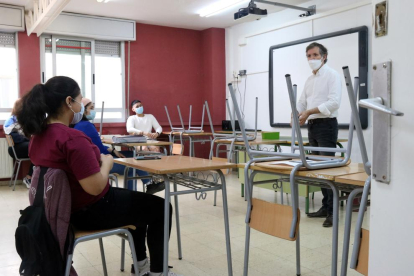 Un profesor de l'IES Joanot Martorell hablando con varios alumnos de segundo de bachillerato en un aula del centro.