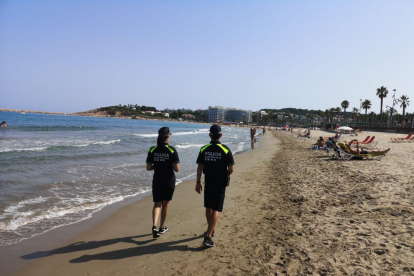 Dos policías patrullando por la playa de la Pineda.