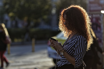 Una mujer utilizando el móbil en la calle.