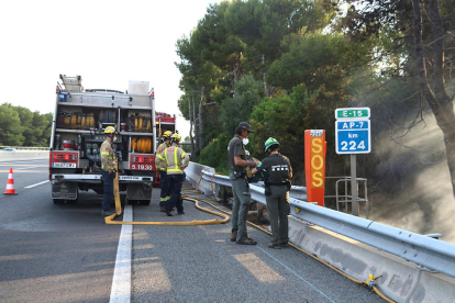 Efectivos de los Bomberos y de los Agentes Rurales trabajando en la extinción del incendio que ha quemado al AP-7 en Roda de Berà en sentido Castellón
