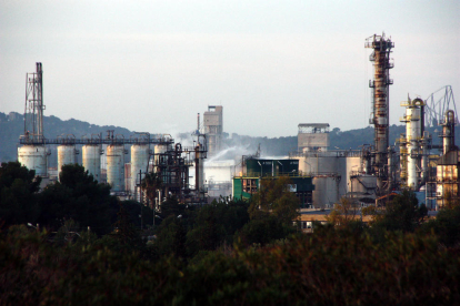 Pla obert de la planta d'IQOXE a la Canonja, al Tarragonès, amb els raigs d'aigua dels Bombers remullant la zona de l'explosió.