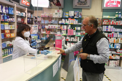 Un home adquireix una mascareta a la Farmàcia Ferrús de Reus el 20 d'abril.
