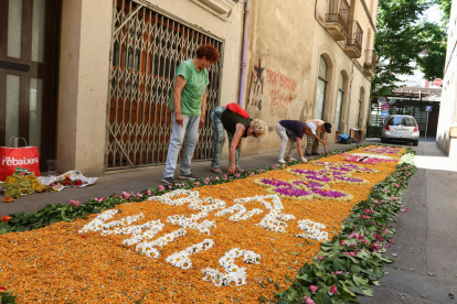 Unas mujeres montando una alfombra de flores en Valls, en motivo de la celebración del Corpus, ayer.