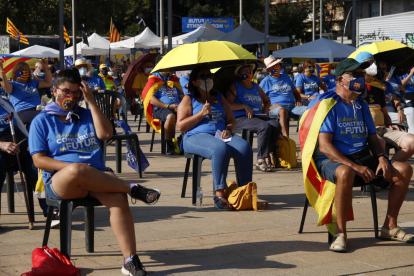 El públic es protegeix del sol durant l'acte de l'ANC en motiu de la Diada a la plaça dels Països Catalans de Barcelona.