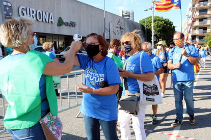 Una voluntària de l'ANC prenent la temperatura a l'entrada de la concentració de Girona